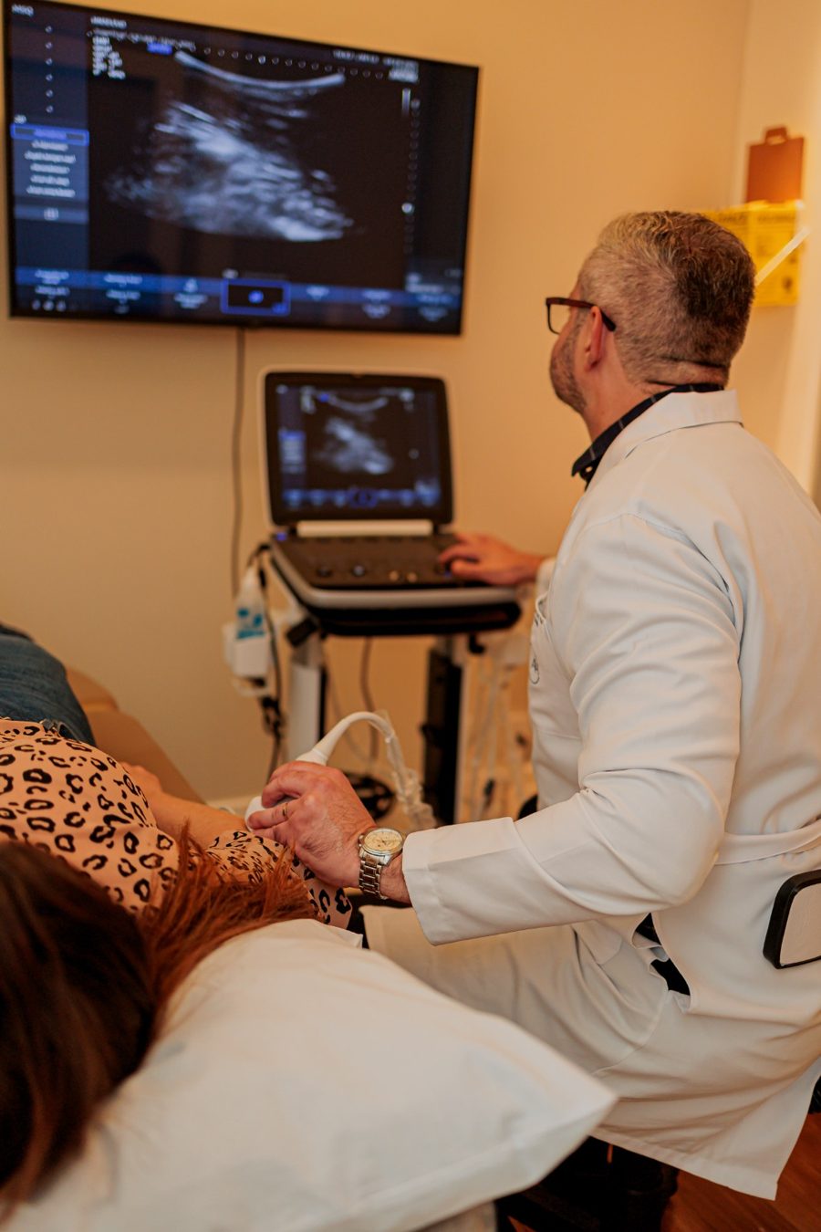 Dr. Arthur Henrique realizando exame de ultrassom do ombro no consultório
